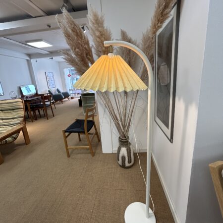 Hvid gulvlampe med plisseret skærm.