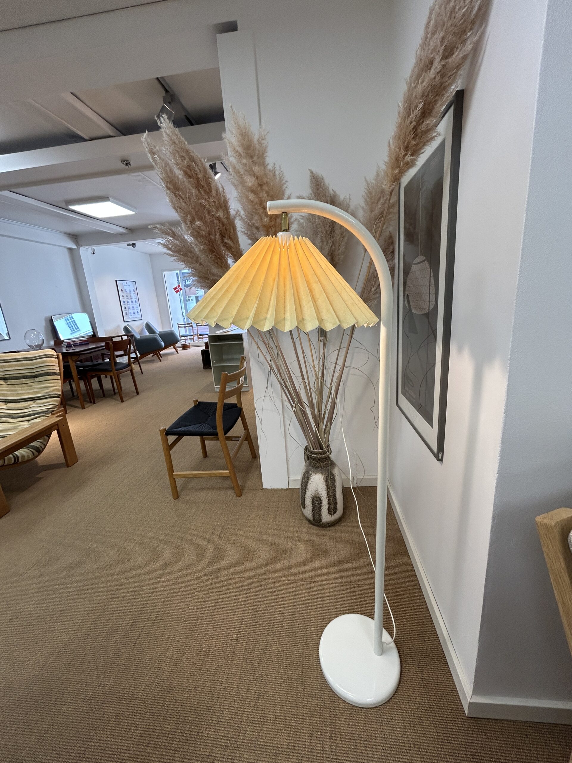 Hvid gulvlampe med plisseret skærm.